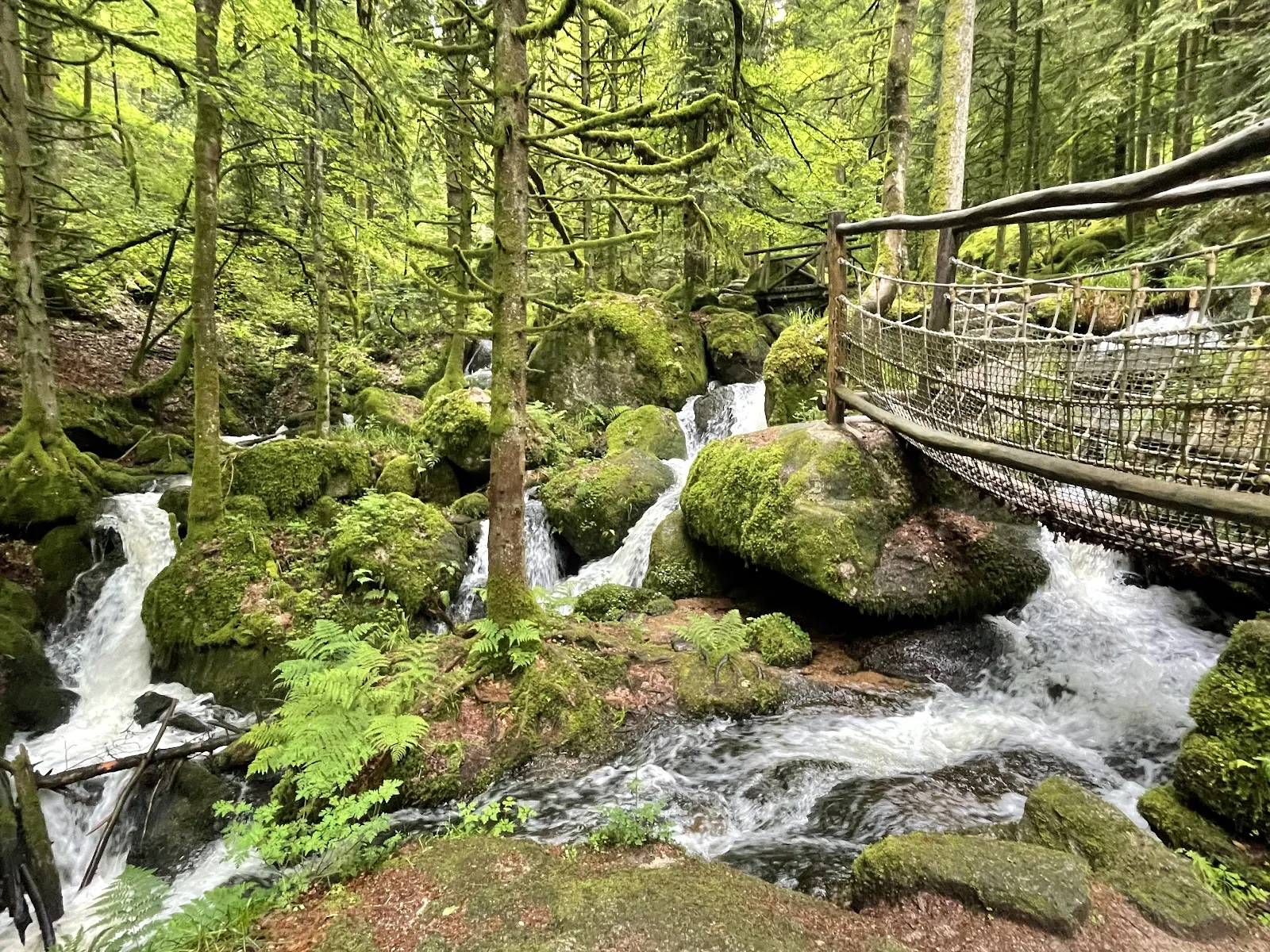Водопад Гертэльбах, падающий по скалам, окруженный зеленью.