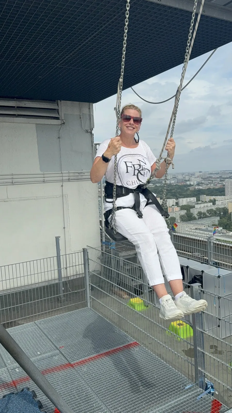 Люди, катающиеся на качелях High Swing Berlin с видом на город