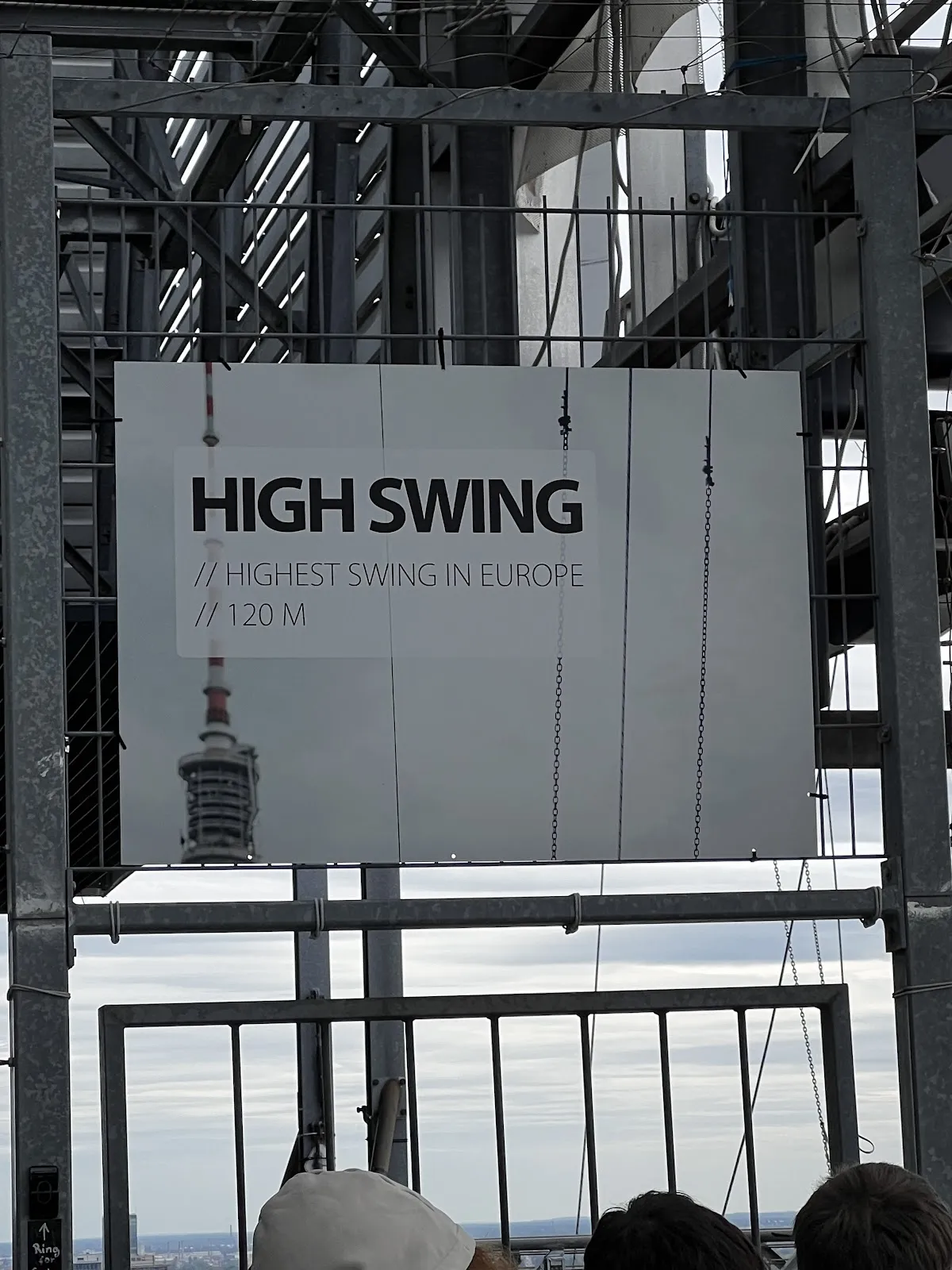 Люди, катающиеся на качелях High Swing Berlin с видом на город