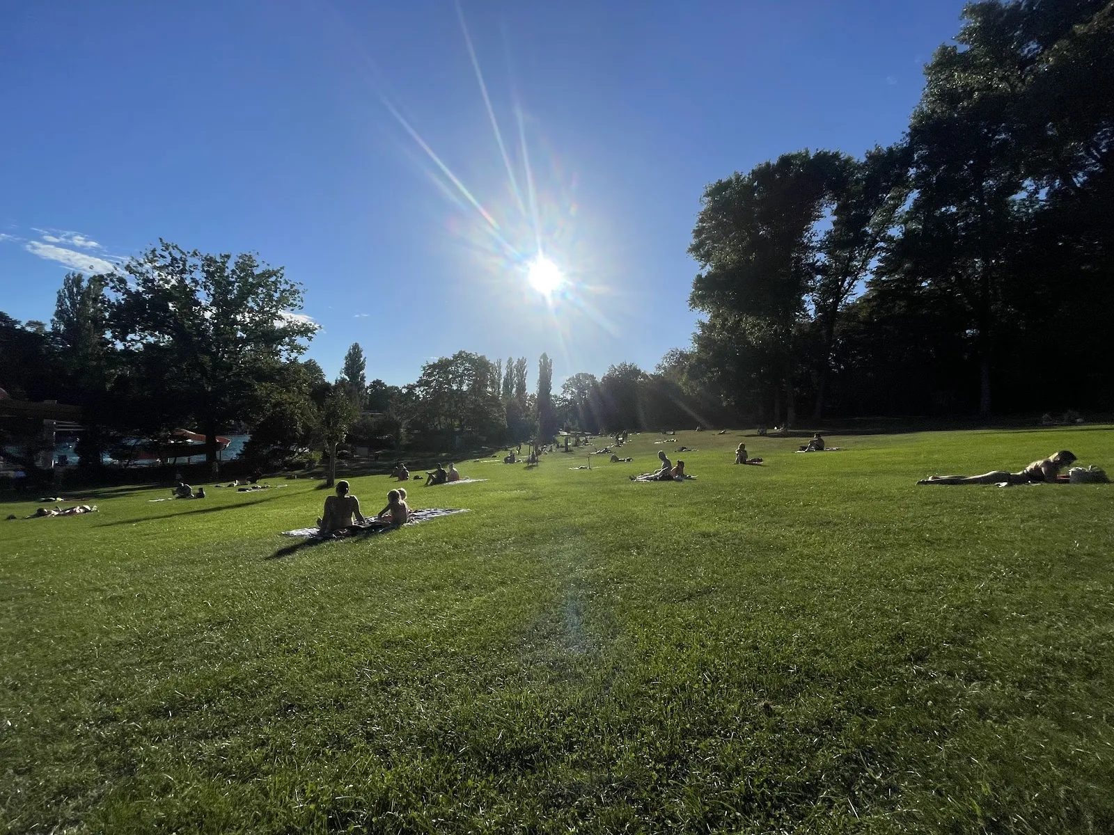 Люди купаются и отдыхают у открытого бассейна Sommerbad Neukölln в Берлине.