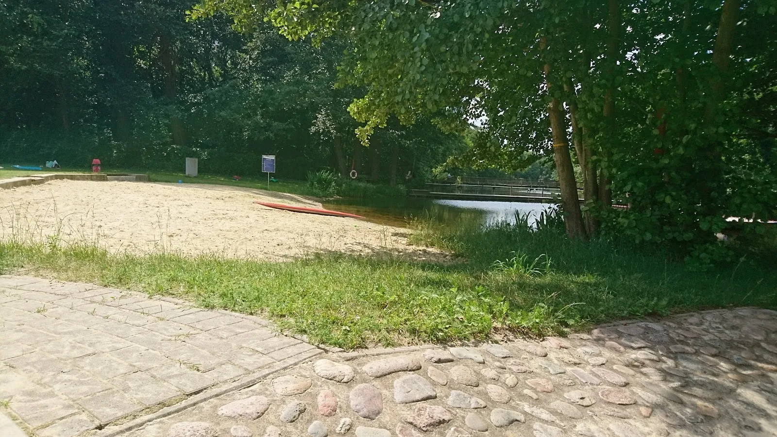 Вид на летний пляж озера Грамбкер с людьми, отдыхающими на берегу