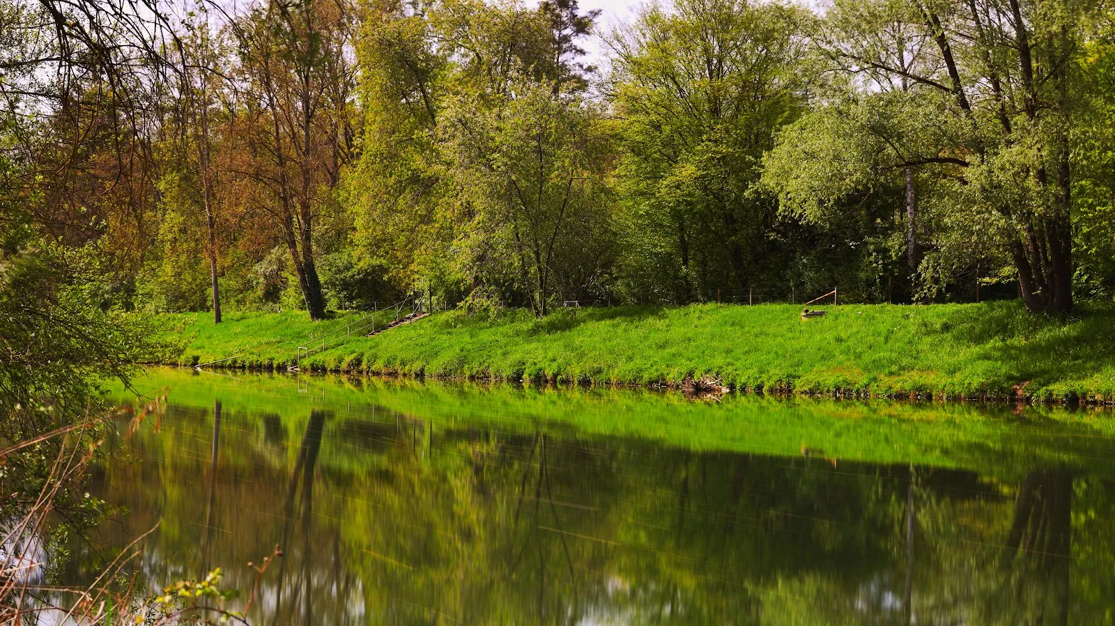 Вид на озеро Бойтванг в Нюртингене, Германия, с зелеными берегами и чистой водой.