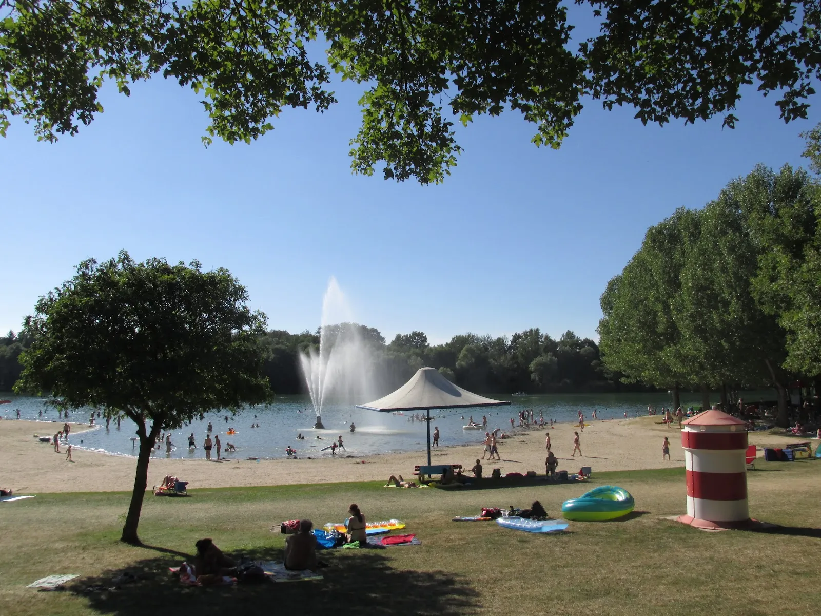 Вид на озеро Бухциг с зеленой травой и деревьями.