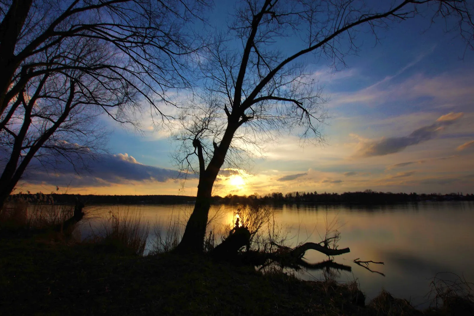 Пляж Гроссе Штайнланке в Берлине с людьми, отдыхающими на берегу у воды.