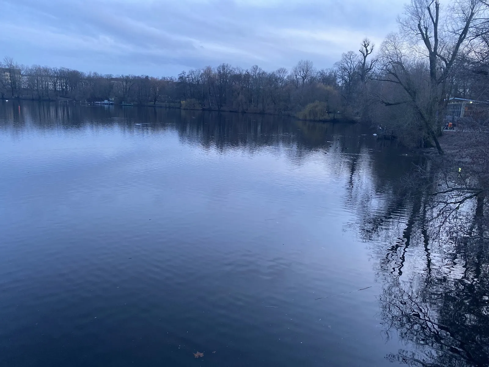 Пляж Вайсензее с людьми, загорающими и купающимися в озере.