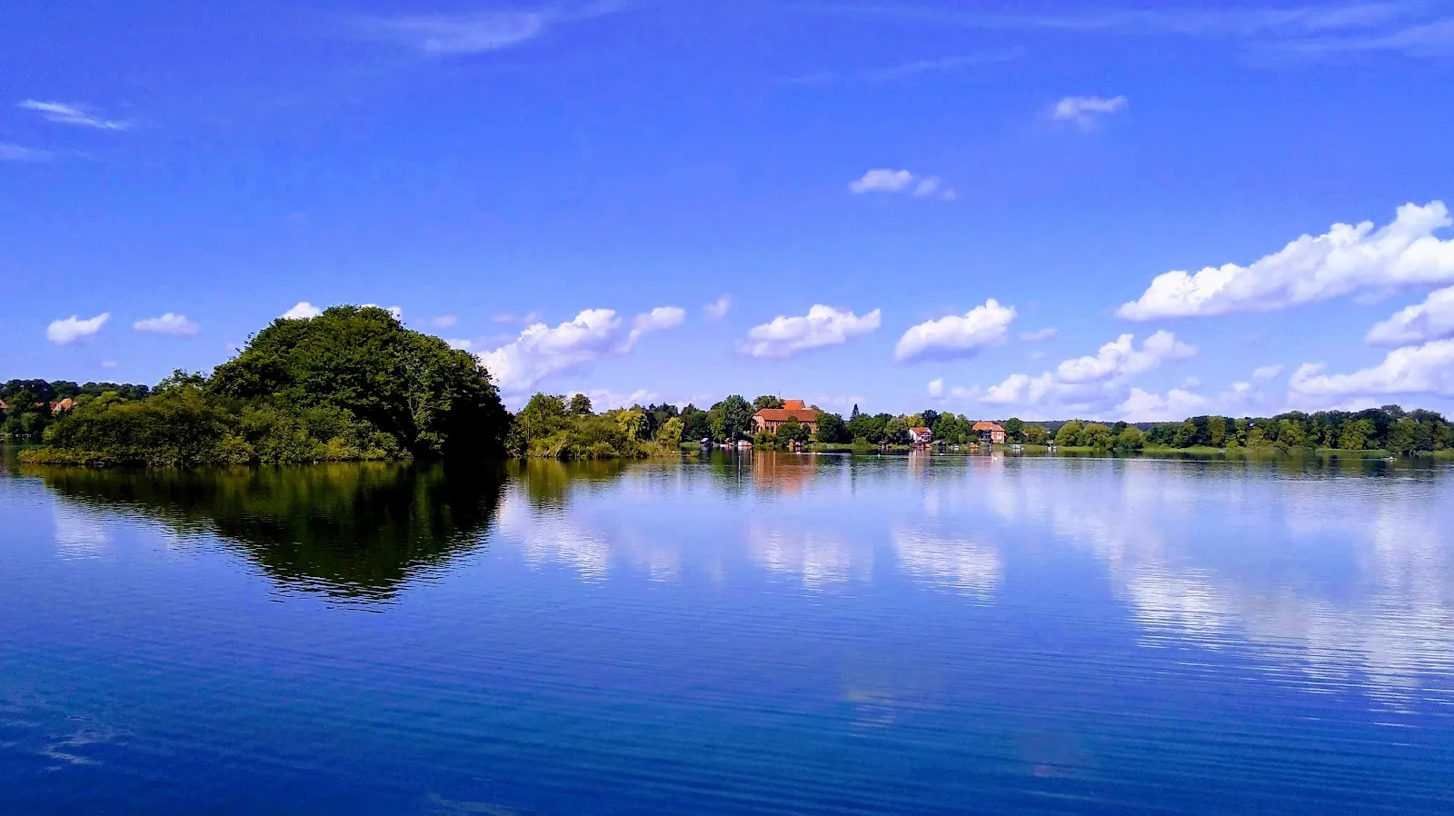 Озеро Шаальзее с зелеными холмами на берегу