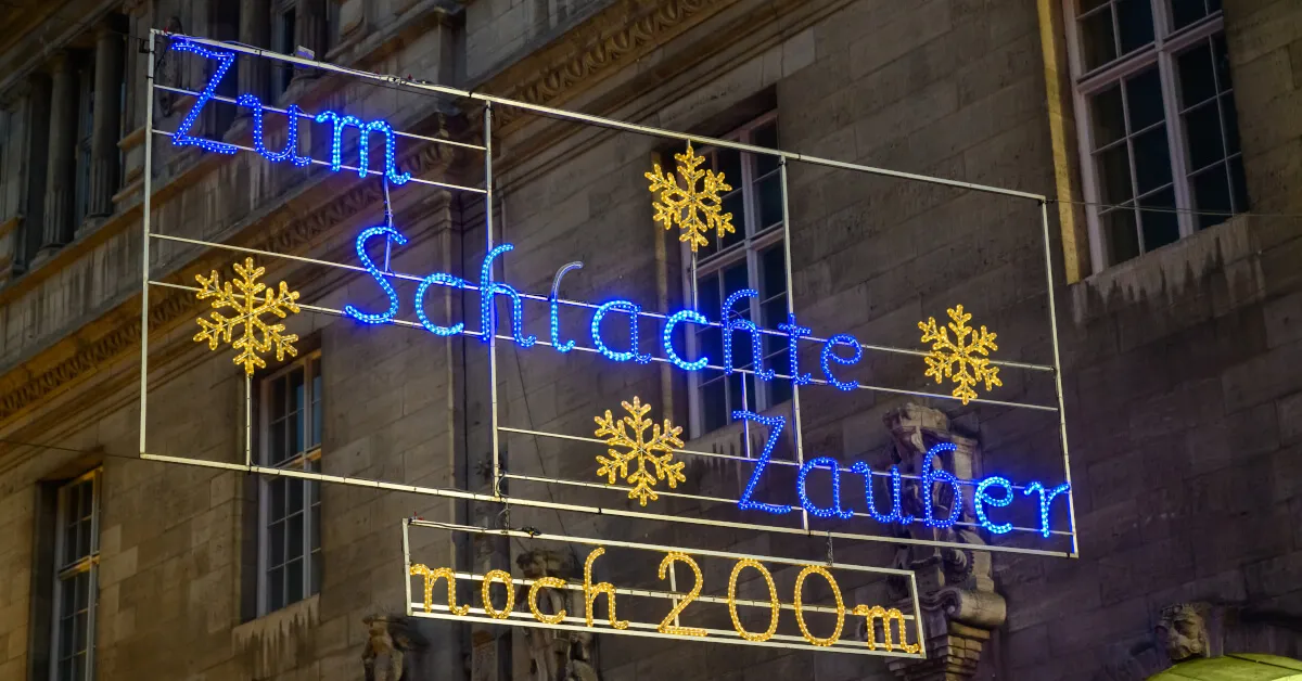 Люди гуляют по набережной Шлахте в Бремене, Германия, с магазинами и кафе.