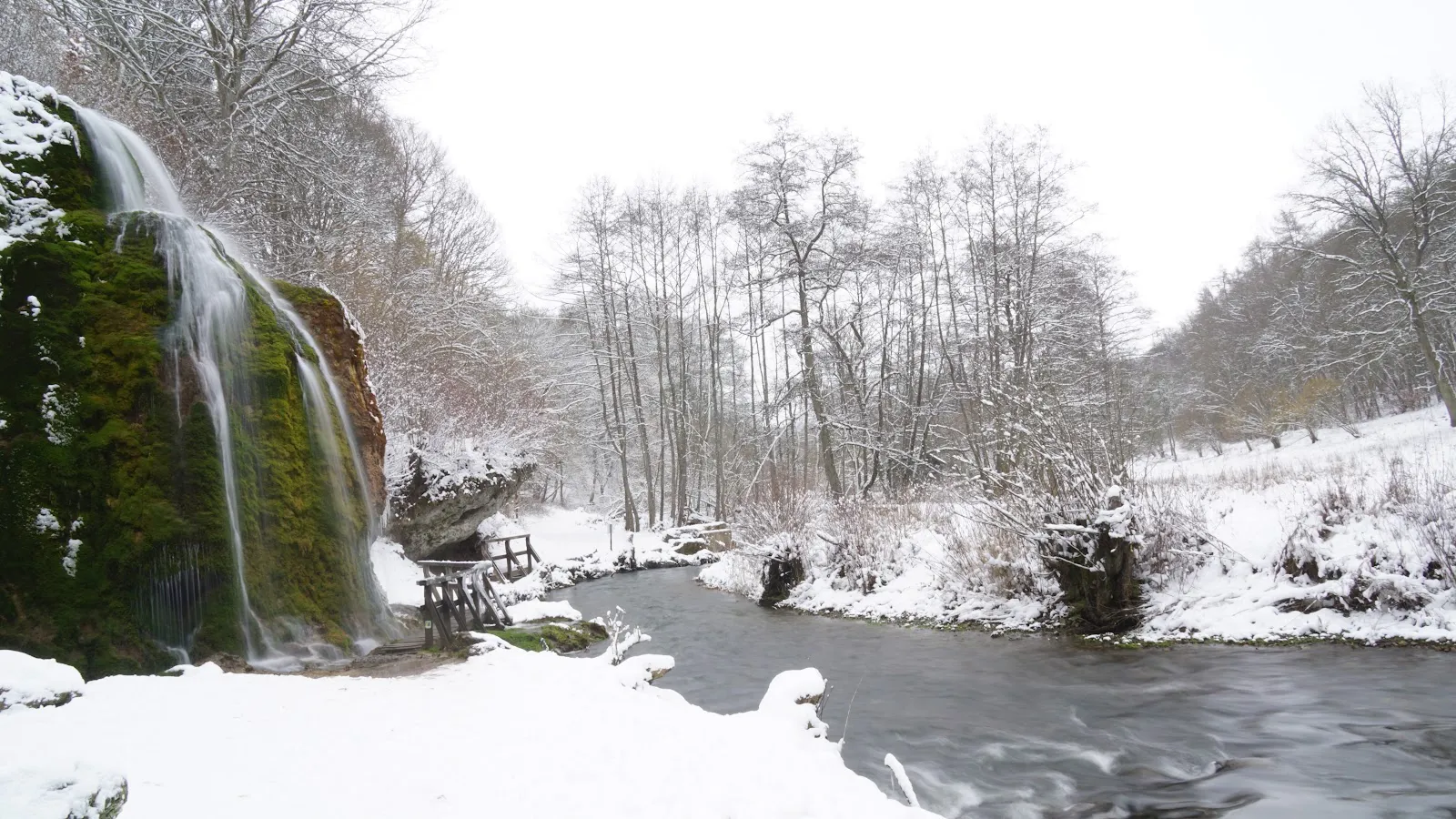 Вид на водопад Драймюлен с падающей водой и окружающим лесом