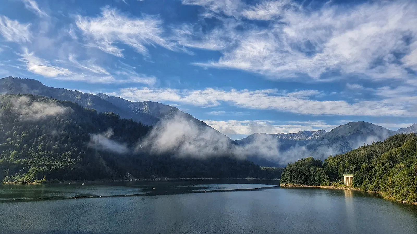 Вид на озеро Зильвенштайнзее с плотиной и горами на заднем плане